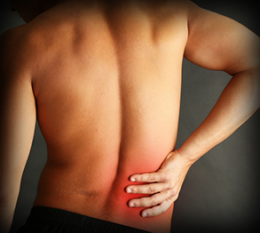 Young man with back pain on grey background